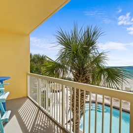 Sip your morning coffee from turquoise chairs while gazing at sparkling pool waters and pristine beach beyond swaying palms.