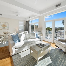 Sink into plush white sofas in your bright living space, where coastal artwork and French doors lead to your private balcony.