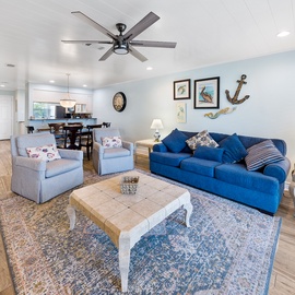 Sink into the plush blue sofa and feel instantly at home in this bright, coastal-themed living space with nautical touches.