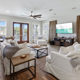 Sink into plush white sofas while gentle ceiling fans keep you cool in this bright, open living space.
