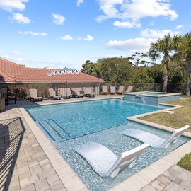 Dive into your private oasis with sparkling pool, bubbling spa, and loungers surrounded by tropical palms and sunny skies.