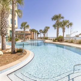 Sparkling turquoise pool surrounded by swaying palm trees creates your perfect tropical oasis steps from the beach.