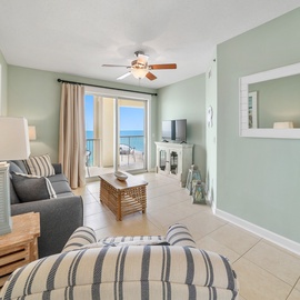 Relax in your coastal living room with soft sea-green walls and stunning ocean views through sliding doors.