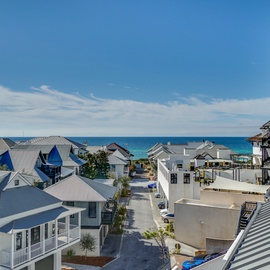 Charming beachside neighborhood with coastal architecture and stunning turquoise waters just steps away from this elevated location.