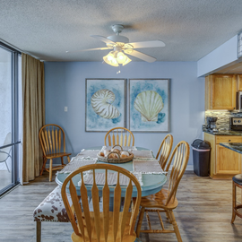 Enjoy meals in your bright dining area with ocean-themed art while the coastal breeze flows from your private balcony.