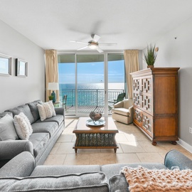 Relax in your elegant living space with panoramic ocean views from floor-to-ceiling windows and a private balcony for unforgettable sunrises.