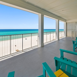 Wake up to stunning turquoise waters from your private beachfront balcony, where colorful chairs await your morning coffee and endless ocean views.