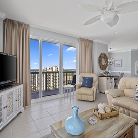 Relax in your spacious living room with comfortable seating, entertainment center, and stunning balcony views of the city skyline.