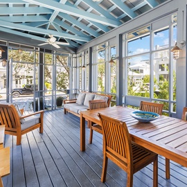 Step into your screened porch where teak furniture awaits for meals and relaxation surrounded by natural light and garden views.