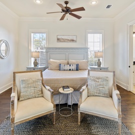 Unwind in your serene bedroom where coastal colors meet elegant comfort, complete with seating area for morning coffee.
