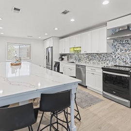 Step into your modern kitchen with gleaming marble countertops, stainless steel appliances, and stylish mosaic backsplash where culinary adventures await.