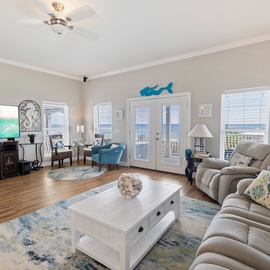 Step into your coastal retreat where soft gray walls meet ocean-inspired décor. Through the French doors, an authentic beach view stretches across the horizon—your peaceful escape from everyday life.