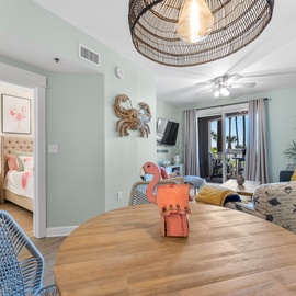 Relax in your coastal-themed living space with soft sea-green walls, comfortable seating, and a glimpse of your peaceful bedroom retreat.