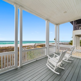 Sway in your rocking chair while turquoise waves dance before you on this covered porch—your perfect perch for morning coffee and endless ocean views.