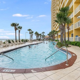 Stunning beachfront resort with expansive swimming pool, palm-lined promenade, and direct access to pristine sandy shores.
