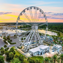 A stunning Ferris wheel landmark dominates the sunset skyline, creating a picturesque backdrop for your stay.