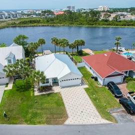 Waterfront community with lakeside homes featuring private driveways and tropical landscaping in a peaceful residential setting.