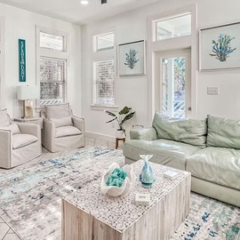 Sink into coastal comfort in your bright living room, where soft mint sofas and ocean artwork create the perfect space to unwind.