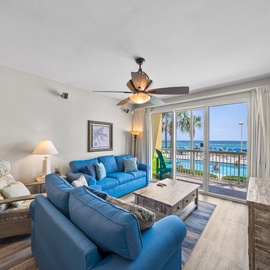 Relax in your coastal living room with ocean views and vibrant blue furnishings that mirror the sea beyond your balcony.