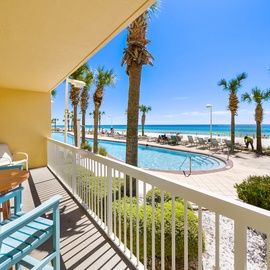 Your beachfront balcony offers stunning views of turquoise waters, swaying palms, and the sparkling pool below—perfect for morning coffee or sunset relaxation.