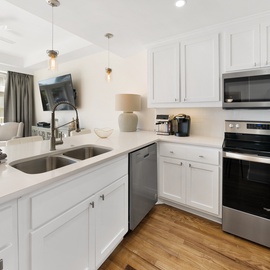 Your gleaming white kitchen features modern appliances and spacious counters, perfect for preparing memorable vacation meals together.