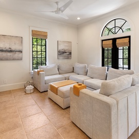 Sink into plush sectional seating while your ceiling fan keeps you cool and garden views frame your relaxation time.