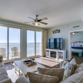 Sink into coastal comfort in your beachfront living room, where ocean views stretch endlessly beyond your private balcony.
