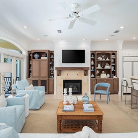 Your open-plan living space blends comfort and elegance, featuring plush seating, a cozy fireplace, and seamless kitchen connection.