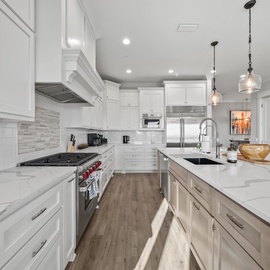 Your gourmet kitchen features pristine marble countertops, professional-grade appliances, and elegant pendant lighting for memorable culinary experiences.