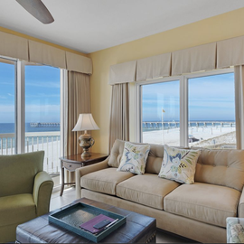 Relax in your comfortable living room with panoramic ocean views through floor-to-ceiling windows.