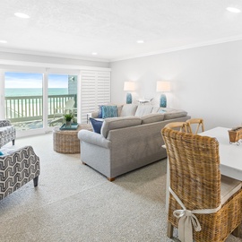 Relax in your bright coastal living space with stunning ocean views through sliding glass doors and comfortable seating for memorable meals.