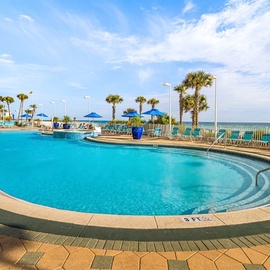 Sparkling beachfront pool with panoramic ocean views and palm trees creates your perfect tropical escape.