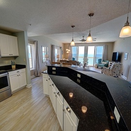 Your gourmet kitchen features granite countertops and opens to stunning ocean views, perfect for cooking while enjoying the sea breeze.