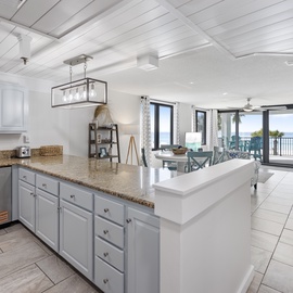 Your stylish kitchen flows seamlessly into the living space, where you'll cook with stunning ocean views through floor-to-ceiling windows.