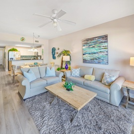 Sink into plush sofas in this bright, open living space where coastal blues meet warm wood tones, creating your perfect retreat.