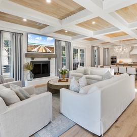 Relax in your elegant living space featuring a stunning coffered ceiling and cozy fireplace, perfect for unwinding after exploring.
