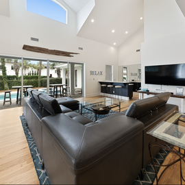 Unwind in your stylish open living space with soaring ceilings, sleek furnishings, and seamless indoor-outdoor flow to the pool area.