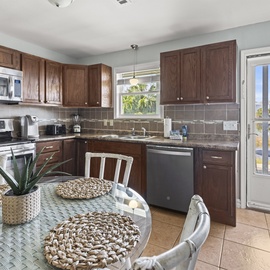Your fully equipped kitchen features granite counters, stainless appliances, and opens to your private balcony with scenic views.