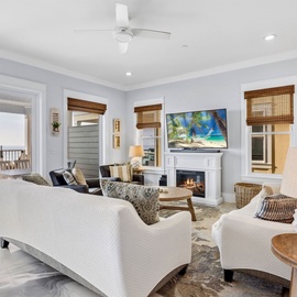 Sink into plush seating by your cozy fireplace while tropical scenes dance on the smart TV in this elegantly appointed living room.