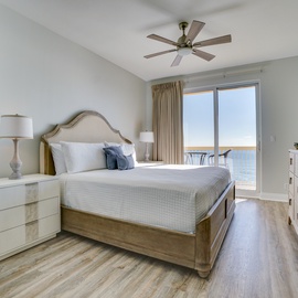 Unwind in your elegant bedroom with soothing sea breezes from the ceiling fan and stunning ocean views just beyond your balcony doors.