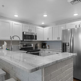 Your modern kitchen features marble countertops, stainless steel appliances, and an island perfect for cooking and casual dining together.
