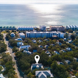 Charming beachside community featuring colorful homes nestled among lush trees, just moments from pristine coastline and modern resort facilities.