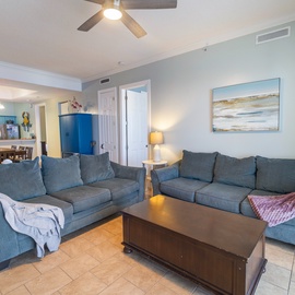 Settle into your spacious living area with plush sofas and an open layout that flows seamlessly into the dining and kitchen spaces—perfect for gathering with family and friends.