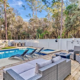 Your private oasis awaits with a sparkling pool, spa, and comfortable outdoor lounge surrounded by peaceful bushland.