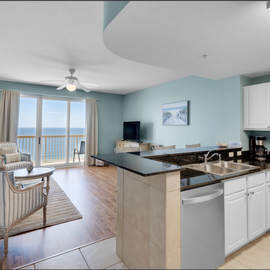 Your oceanfront condo flows seamlessly from kitchen to living area, with stunning sea views through floor-to-ceiling windows creating the perfect coastal retreat.