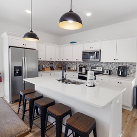 Your gourmet kitchen awaits with stainless steel appliances, a spacious island for gathering, and serene coastal views that invite you to cook and create in paradise.