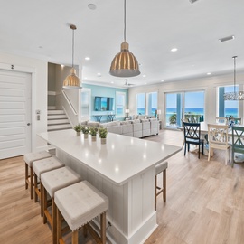 Your open-concept living space flows seamlessly from kitchen to dining, with stunning ocean views framing every moment of your coastal getaway.