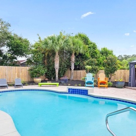 Dive into your private oasis with sparkling pool waters, shaded lounging areas, and tropical palms creating the perfect backyard retreat.