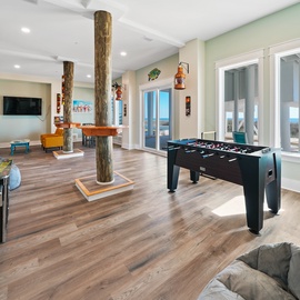 Your private game room awaits with foosball, arcade fun, and ocean views through expansive windows—perfect for family entertainment.