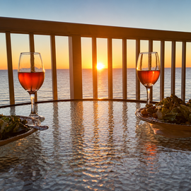 Sip your evening wine on your private balcony as golden sunset light dances across the ocean horizon.